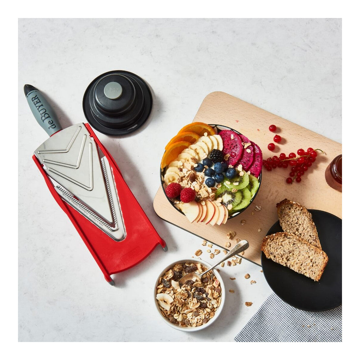 Mandoline Kobra de Buyer avec poussoir de sécurité et fruits découpés