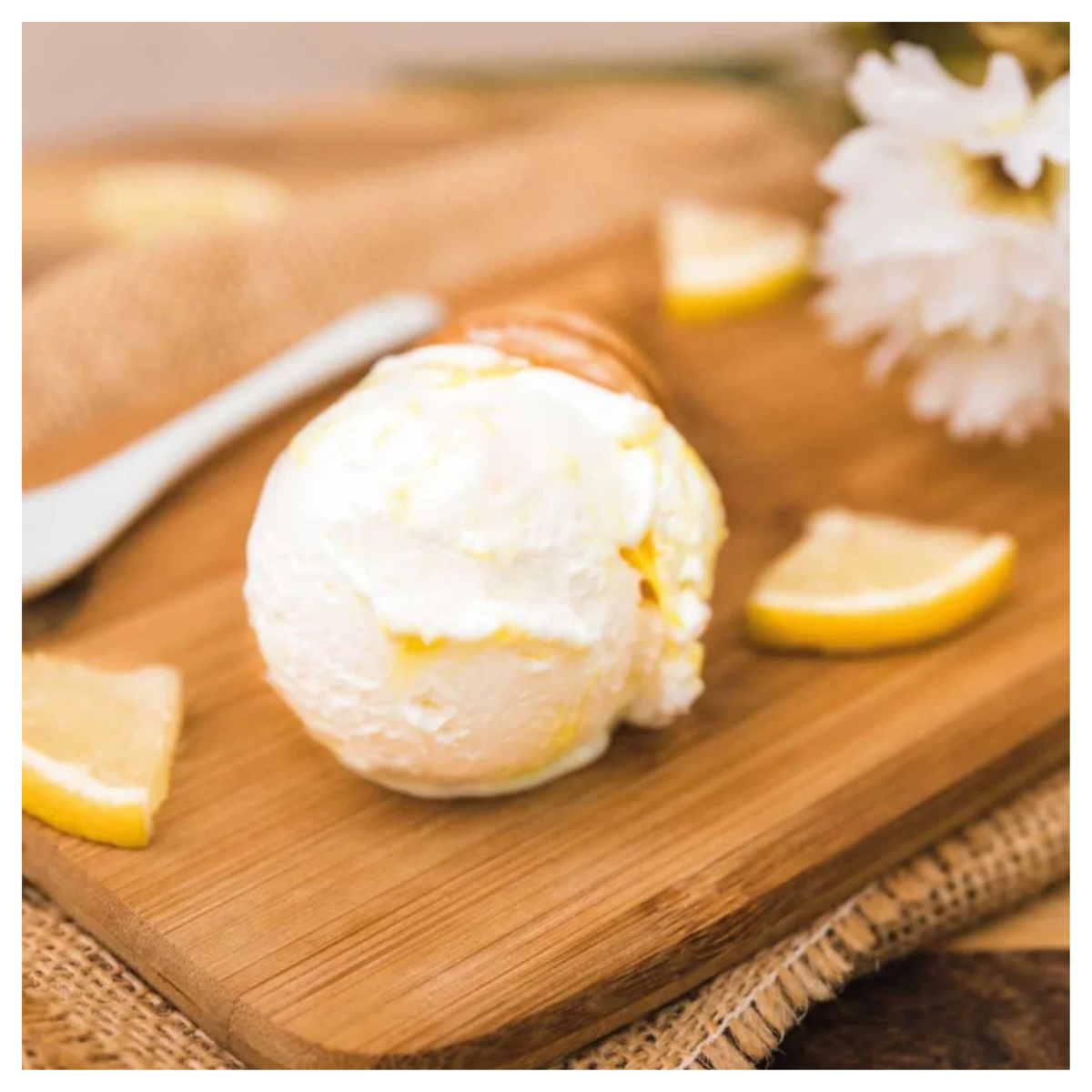 Boule de glace blanche sur planche en bois avec morceaux de citron