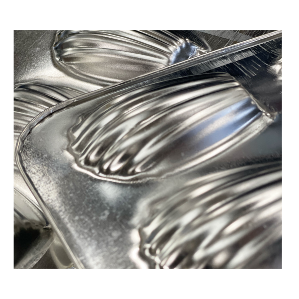 Moule à madeleines en métal, détail des empreintes striées