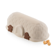 Entremets glacé en forme d’igloo beige décoré de deux pingouins en chocolat et de noisettes