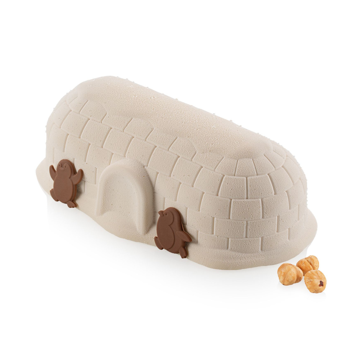 Entremets glacé en forme d’igloo beige décoré de deux pingouins en chocolat et de noisettes