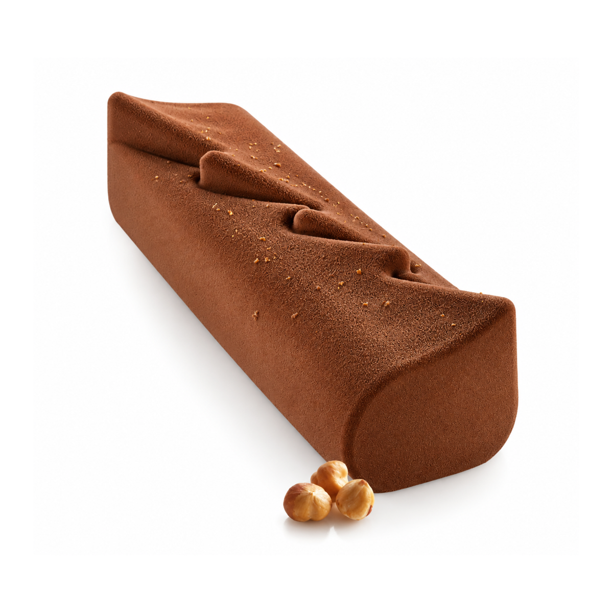 Bûche de Noël au chocolat avec finition velours brun chocolat, reliefs géométriques en zigzag sur le dessus, éclats dorés et noisettes entières en décoration, sur fond blanc.