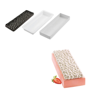Kit moule à bûche Silikomart composé de deux moules rectangulaires blancs, d'un tapis décor noir à effet bulles et d'une bûche pâtissière rose.